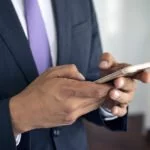 Mann schreibt auf iPhone Tastatur.