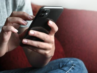 Jugendlicher versendet SMS mit iPhone.