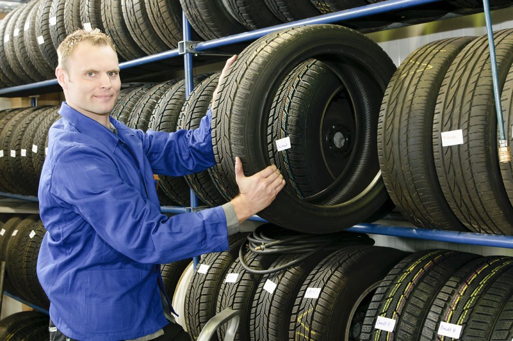 Werkstattmitarbeiter lagert Autoreifen richtig.