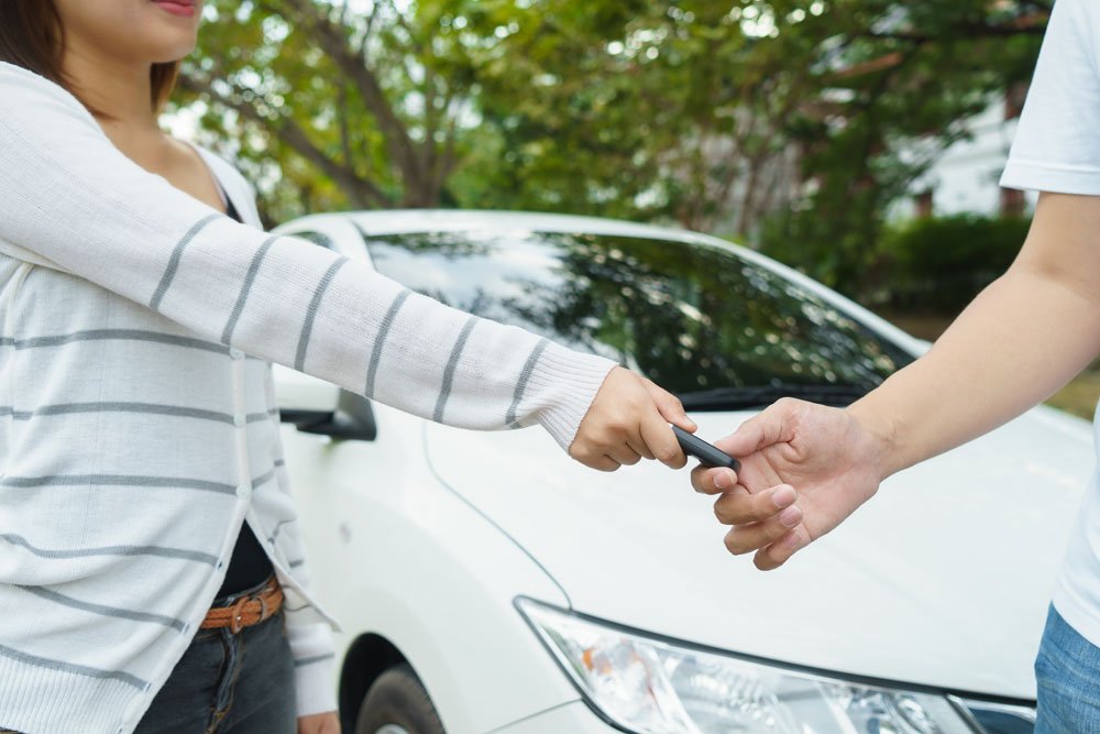 Privater Autoverküfer übergibt Autoschlüssel.