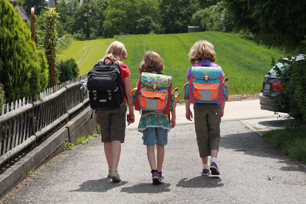 Kinder auf dem Schulweg mit passendem Schulranzen.