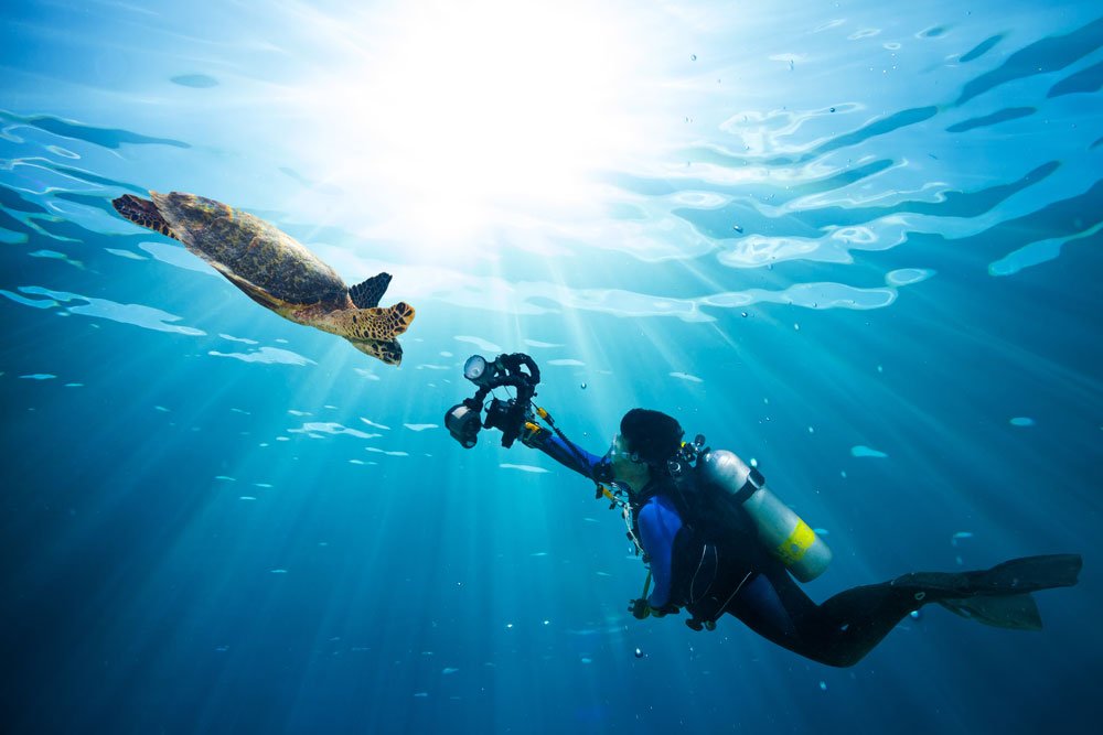 Frau macht Unterwasserfotografie mit Kompaktkamera.